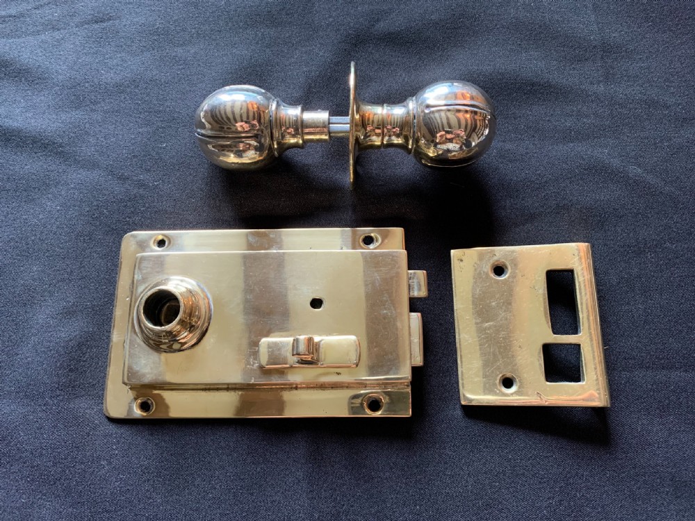 one brass art nouveau door lock with matching door knobs